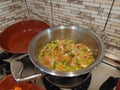 Cooking soup in a metal pan on a gas stove, chicken vegetable soup